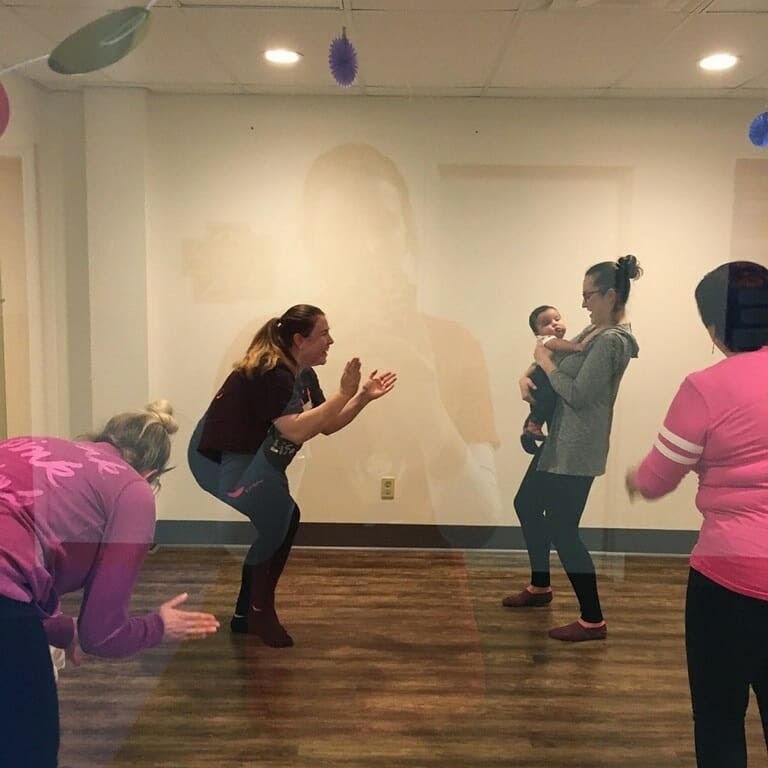 Miss Bri leading a Zumbini class with parents and babies dancing together